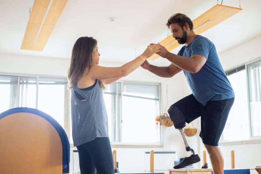 a woman guiding a man on his physical therapy